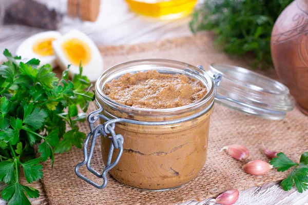 Ahşap arka planda cam kavanozda ev yapımı ciğer ezmesi.