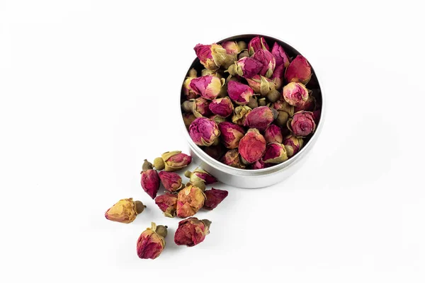 Kırmızı ve pembe gül tomurcukları beyaz arka planda metal konteynırda çay