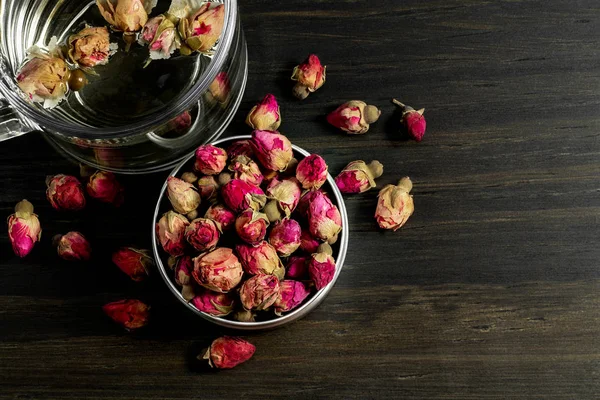 Сушені Трояндові Бруньки Чай Металевій Тарі Супроводжується Скляною Чашкою Фоні — стокове фото