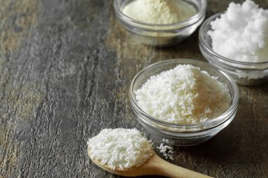 Cam kasede organik hindistan cevizi parçacıkları ve bir kaşık dolusu hindistan cevizi parçacıkları..