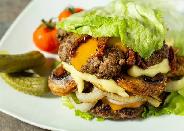 Keto burger, salatalı burger, 2 köfte, mantar, soğan, kurutulmuş domates, peynir ve mayonezli. Turşu ve domatesle servis edilir..