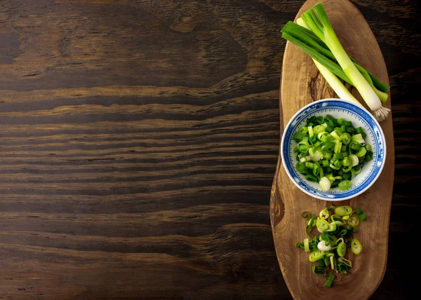 Doğranmış taze soğan, tahtada soğan ve ahşap arka plan..