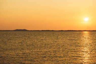 Arka planda deniz ve gün batımı 