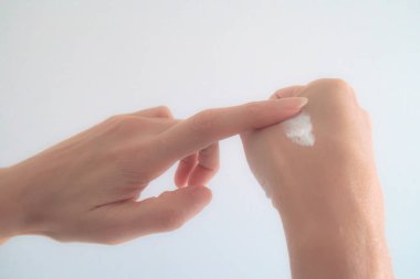 Yakın plan Kadın El, Beyaz Sırt Delisi 'ne Nemlendirici Krem Sürüyor