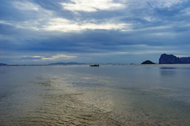 Deniz manzarası ve günbatımı arka planında ada