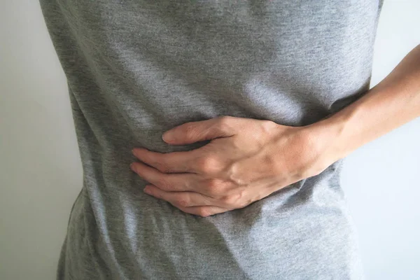 Primer plano mujer dolor de estómago sobre fondo blanco — Foto de Stock