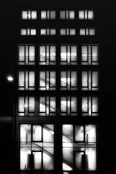 Edifício alto com janelas iluminadas à noite — Fotografia de Stock