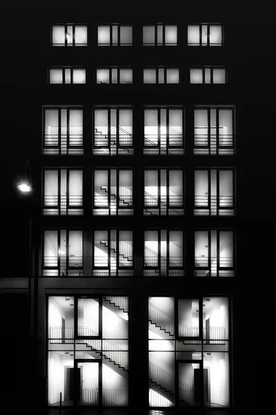 Hochhaus mit beleuchteten Fenstern in der Nacht Stockbild