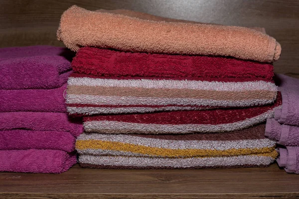 Molti asciugamani colorati impilati nell'armadio — Foto Stock