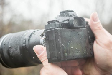 Yağmur altında bir kamera ile bir fotoğrafçı
