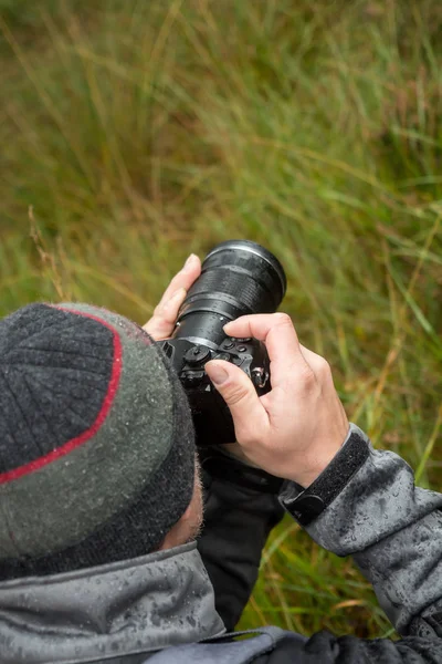 Ein Fotograf mit einer Kamera im Regen — Stockfoto