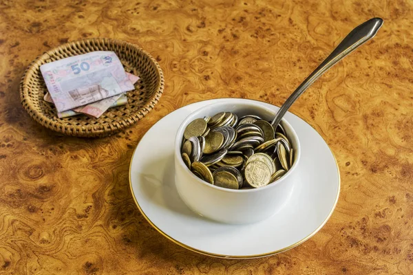 The rise in price of food. Coins instead of soup in a plate. Banknotes instead of bread.