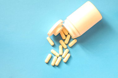 Mavi arka planda haplı bir şişe..