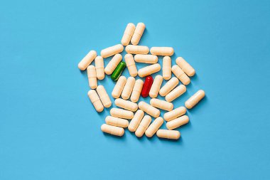 Mavi arka planda beyaz, yeşil ve kırmızı haplar.