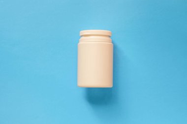 Mavi arka planda haplı bir şişe..