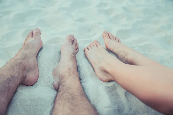 Kvinna och man ben fot i stranden. Fötterna sand. — Stockfoto