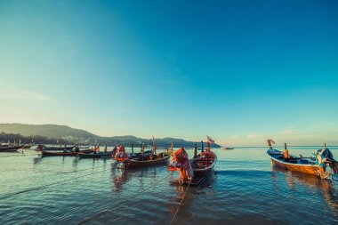 Tay plajda Longtale tekne. ParaDice kum plaj yer. Temiz su ve mavi gündoğumu gökyüzü tekneler.
