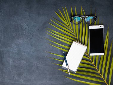 Telefon, gözlük ve karatahta kalemli defter.