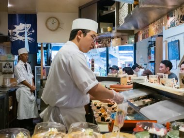 Suşi şefi restoranda suşi yapıyor.