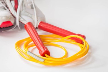 Spor ayakkabılı kırmızı ve sarı renkli atlama ipi
