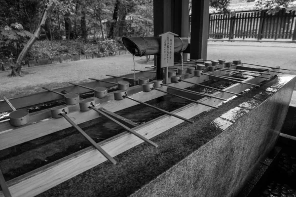 Foto en blanco y negro de A purification trough by the entrance t —  Fotos de Stock