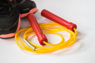 Spor ayakkabılı kırmızı ve sarı renkli atlama ipi