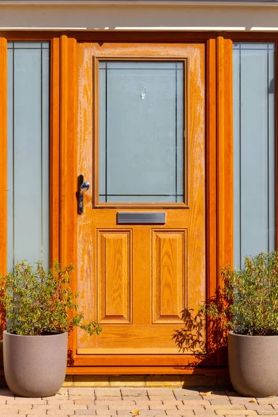 Güzel, sıcak, ahşap ön kapı, doğal ahşap tahıllar ve cam paneller.