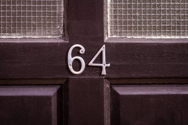 64 numaralı ev siyah ahşap ön kapıda.