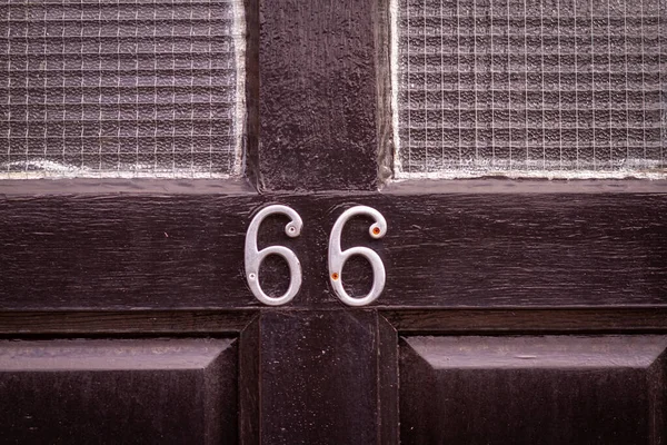 66 numaralı ev siyah ahşap bir ön kapıda.