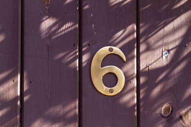 Kahverengi ahşap ön kapıdaki 6 numaralı ev.