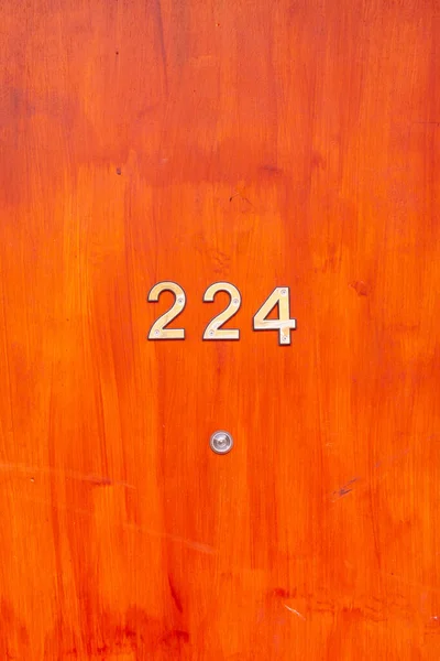 224 numaralı ev ahşap bir ön kapıda.