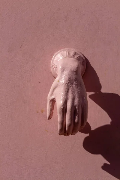 Avuç içi aşağıya bakan açık bir el Londra, İngiltere 'de bir ön kapıda şık bir kapı tokmağı gibi