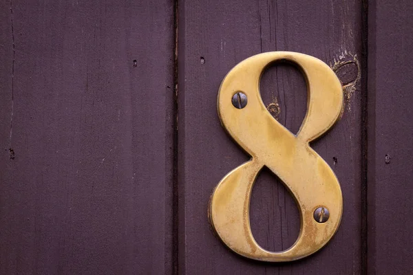 Londra, İngiltere 'de ahşap bir kapıda 8 numaralı ev. Büyük ve cüretkar.