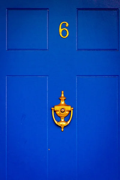 Londra 'da, İngiltere' de, kraliyet mavisi ahşap bir ön kapıda, altın kapı tokmağı ile 6 numaralı ev.