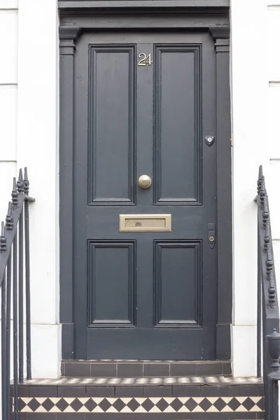 Seçkin görünümlü, koyu renk ahşap ön kapı üzerindeki 24 numaralı ev Londra 'da bütünüyle görülüyor.
