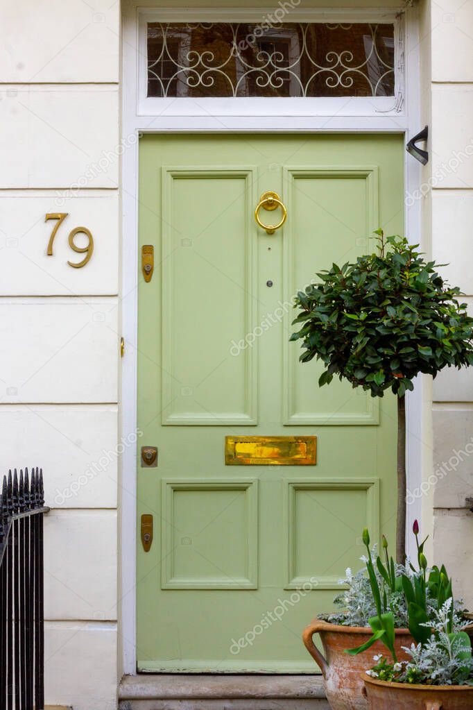 House number 79 on a lime green wooden front door seen in its entirety in London