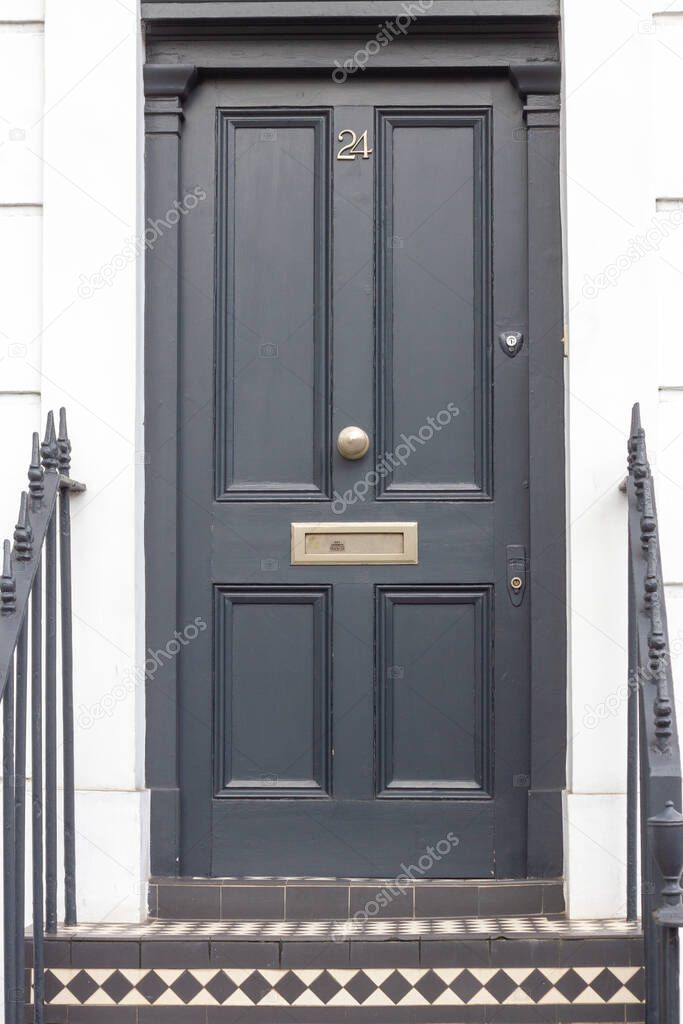 House number 24 on a distinguished looking dark wooden front door seen in its entirety in London