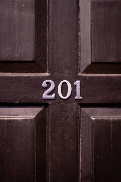 201 numaralı ev siyah ahşap ön kapıda.