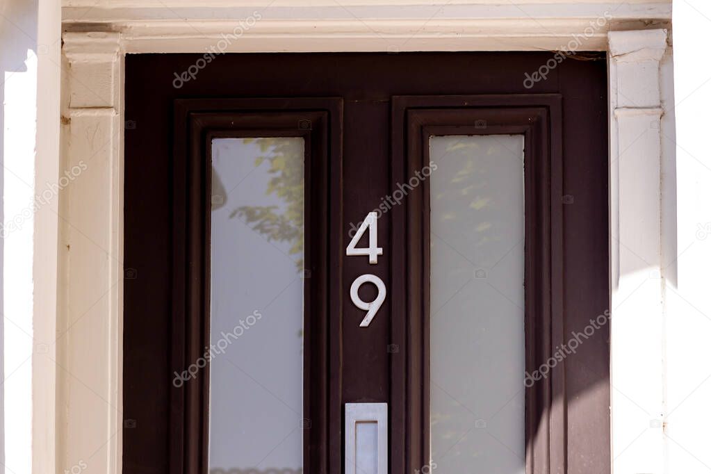 House 49 on a modern front door with glass panels