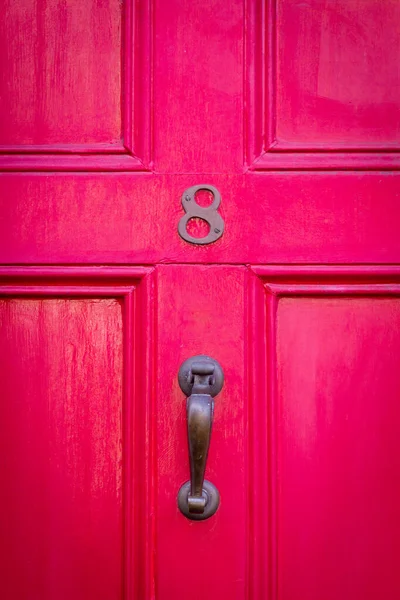 8 numaralı ev kırmızı ahşap ön kapıda.