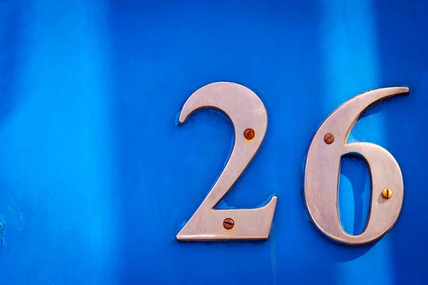 26 numaralı kalın, büyük metal parmaklı ev mavi ahşap ön kapıda.