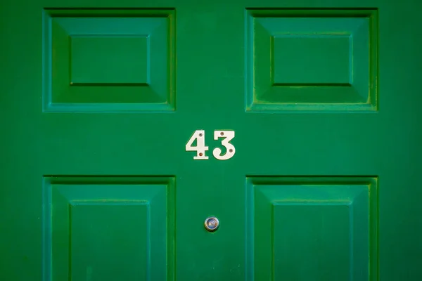 43 numaralı ev yeşil ahşap ön kapıda.
