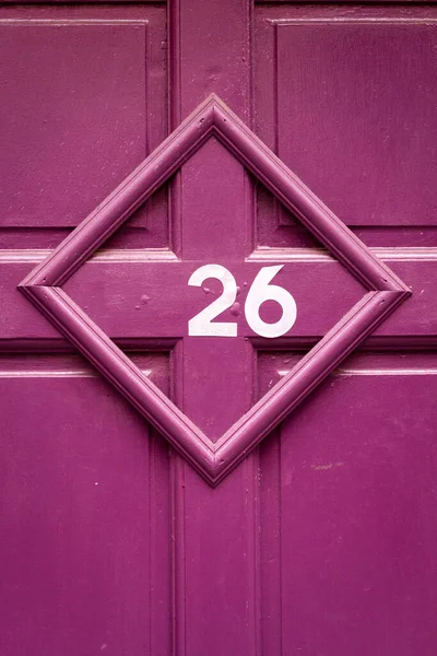 45度の角度で写真フレーム内の紫色の木製のフロントドアの家番号26 — ストック写真