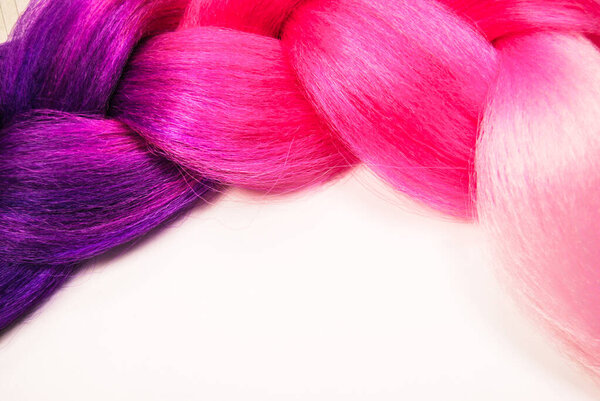 Kanekalon. Colored artificial hair strands. Synthetic hair materials for weaving African braids zizi. Close-up of bright colored hair. Overhead locks. Background for business cards..
