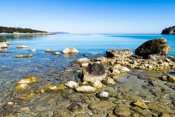 Beautiful idyllic turquoise waters coast with pebbles and rocks. — Stock Photo, Image