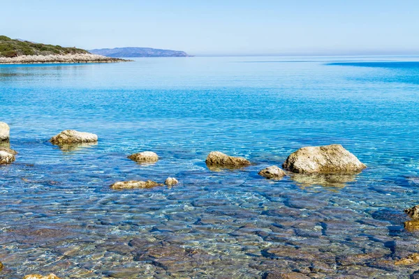 Beautiful idyllic turquoise waters coast with pebbles and rocks. — Stock Photo, Image