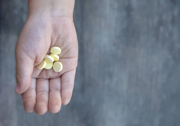 Pílulas de vitamina amarela na mão crianças sujas — Fotografia de Stock