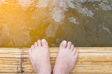 insan ayak bambu üzerinde duran nehirde sal'da