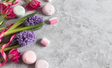 İlkbahar pembe laleler ve mor sümbüllü marşmelovlar ve kadınlar için gri arka planda kasetler 8 Mart