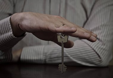 Ofis çalışanı anahtarı olan bir masada oturuyor.